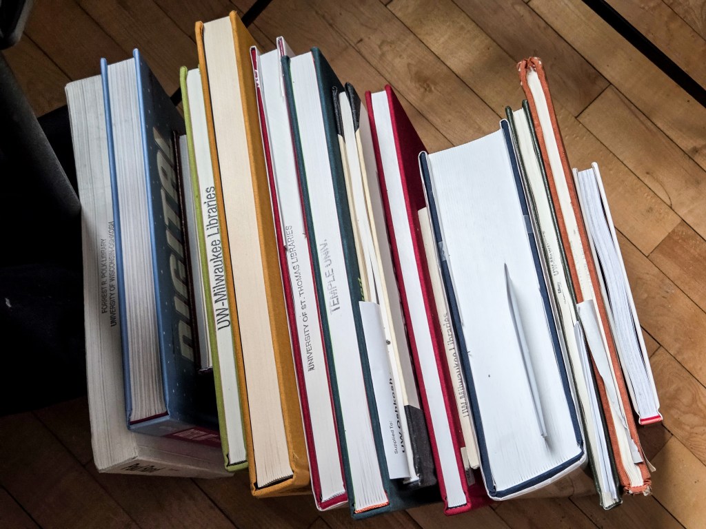 A row of library books sit waiting to be dealt with.